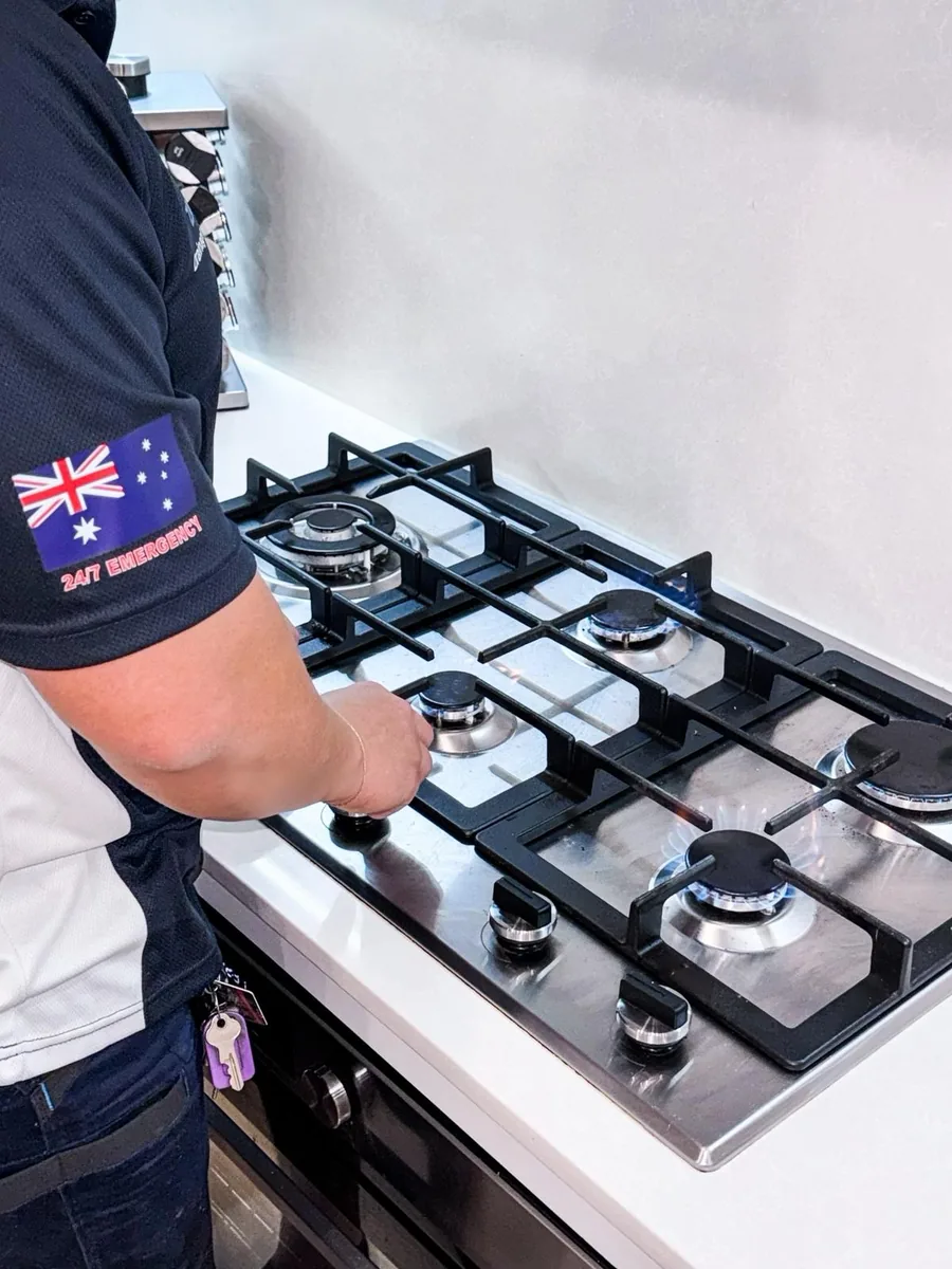 Licensed gas fitter working at a cooktop connection